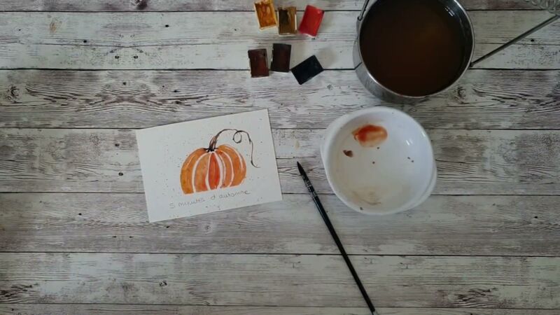 Petite aquarelle d'une citrouille orange aux quartiers séparés de fins blancs, avec une tige brune et une vrille en boucles.